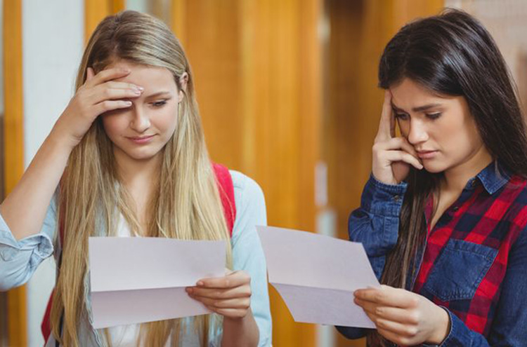 Two young females reading test result documents