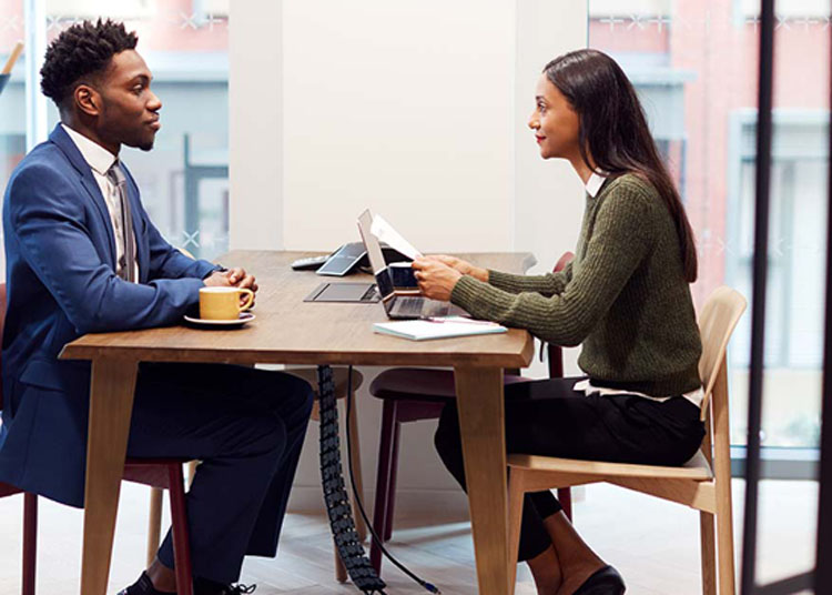 A man and a woman sit across a table from each other