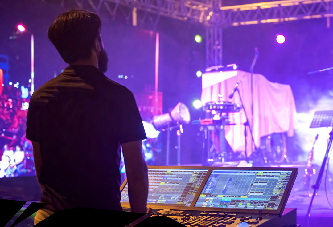Image of man working on mixing desk at concert venue