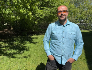 Image of male wearing blue shirt in garden