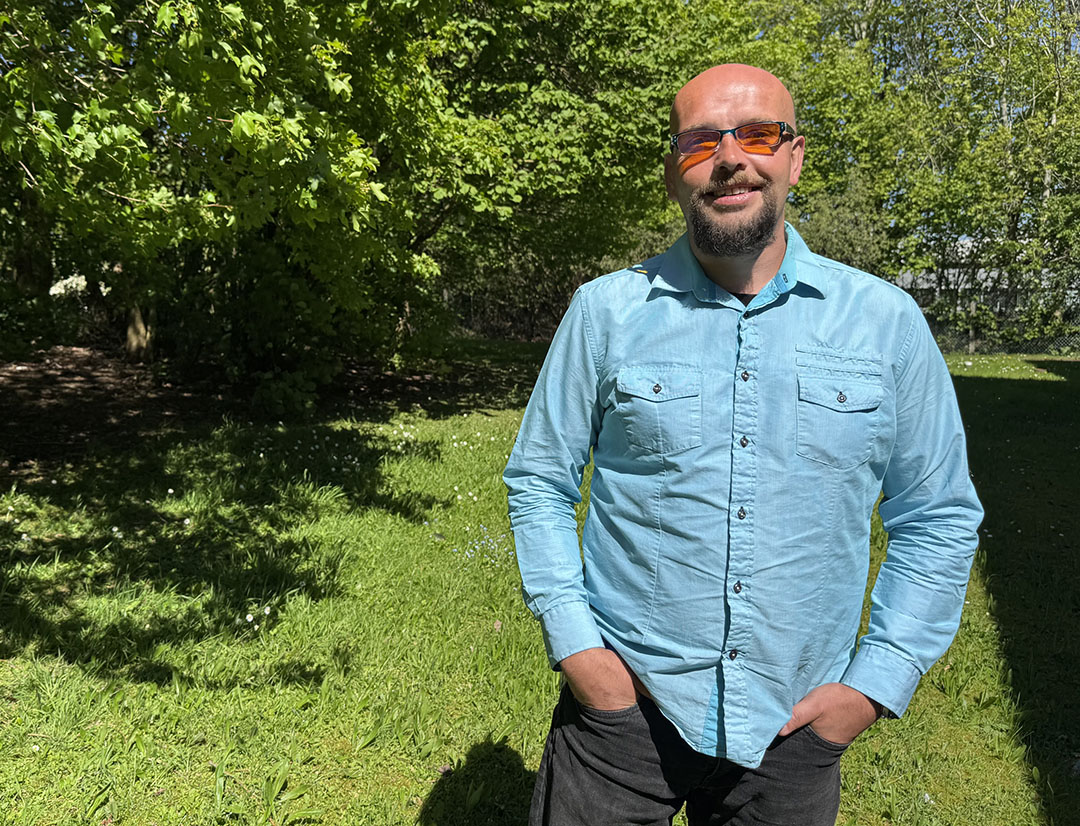 Image of male wearing blue shirt in garden
